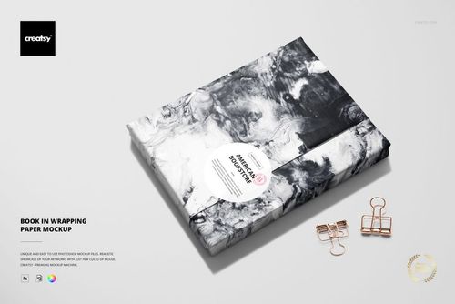 Book in wrapping paper mockup featuring a black and white abstract pattern, shown from above with stationery props.