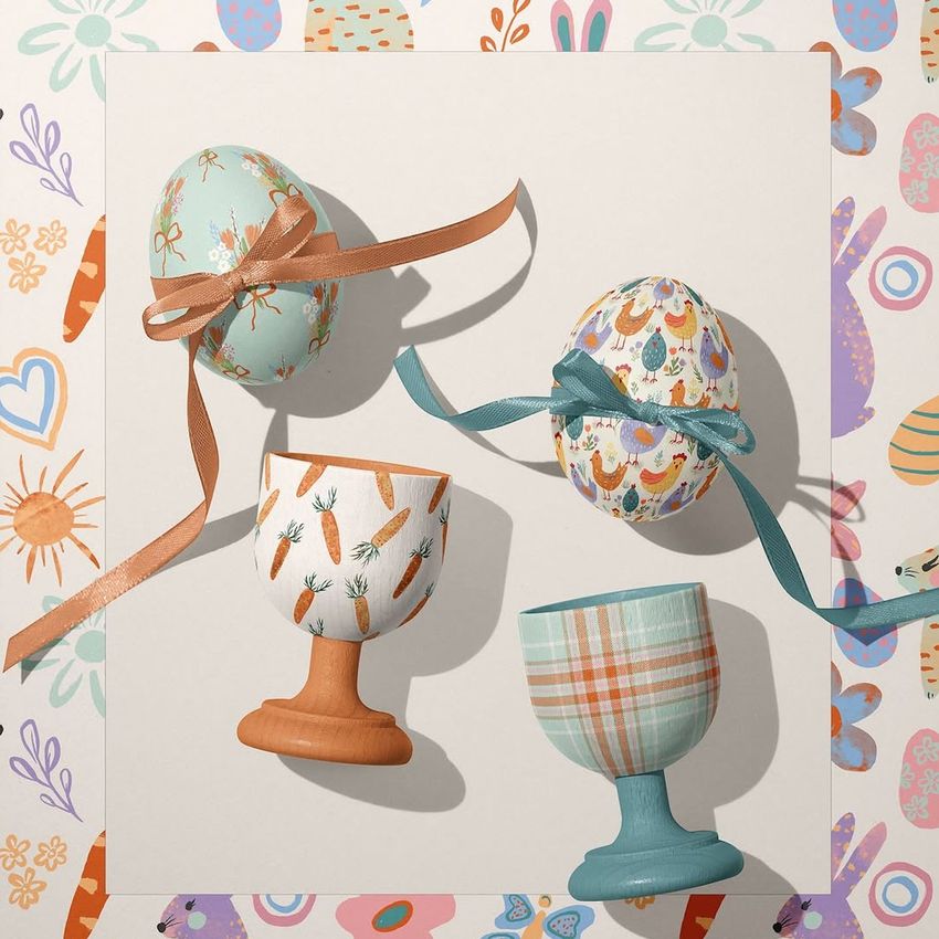 Easter egg crafts mockup featuring two decorated eggs with ribbons and two painted egg cups on a patterned background.