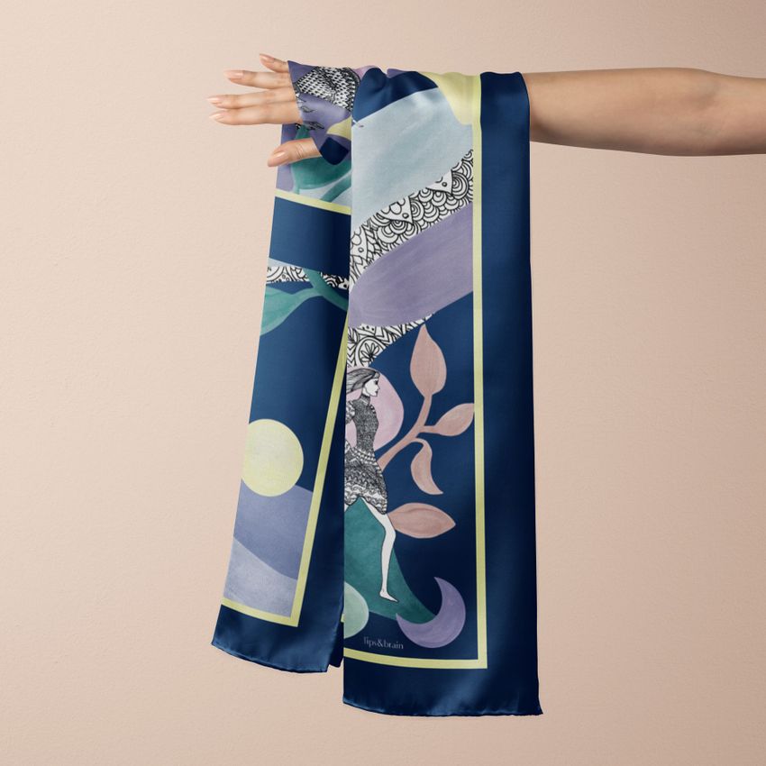 Silk scarf mockup showing a hand holding a draped scarf with abstract patterns in blue, green, and pastel tones against a beige background.