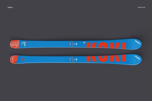 Pair of blue skis with bold orange lettering and abstract orange pattern, displayed on a dark background, top view.