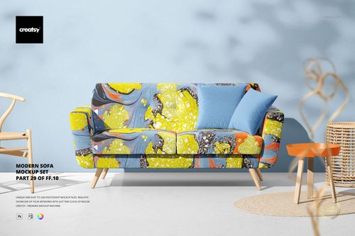 Modern sofa PSD mockup featuring a colorful abstract pattern in yellow and blue, two blue pillows, and a wicker side table on a light background.