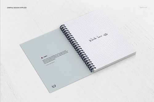 Open spiral notebook mockup with grid paper and handwritten text, displayed on a white wooden surface, top view.