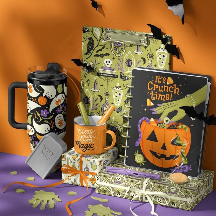 Halloween desk stationery and drinkware mockup featuring a mug, notebook, clipboard, and gift boxes with festive designs.