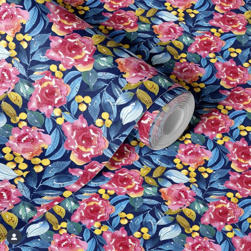 Paper wallpaper mockup featuring a rolled sheet with a vibrant roses and leaves pattern in pink, blue, and yellow tones.
