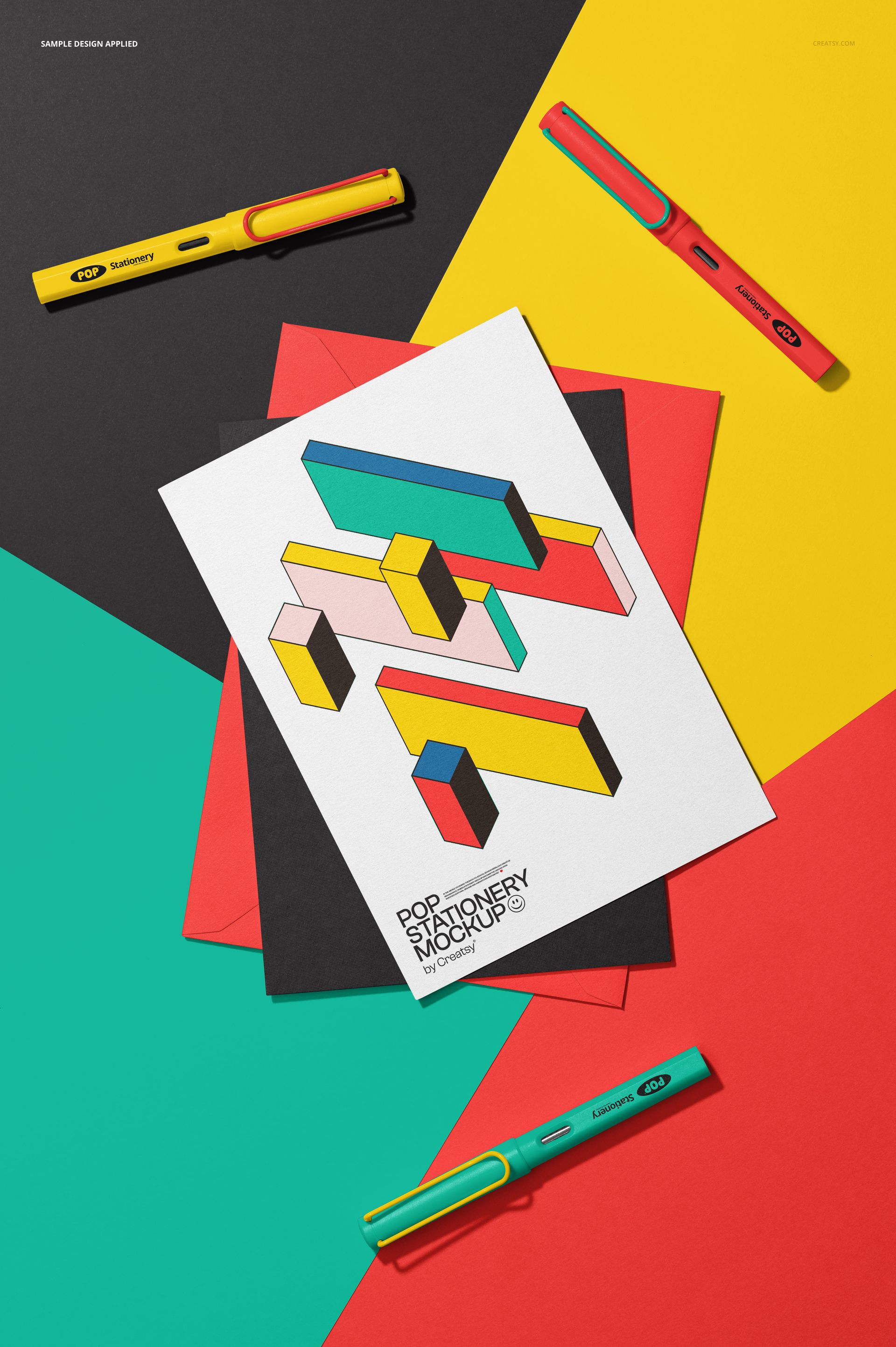 Greeting card mockup with geometric abstract design, placed on colored paper sheets and surrounded by pens, top view.