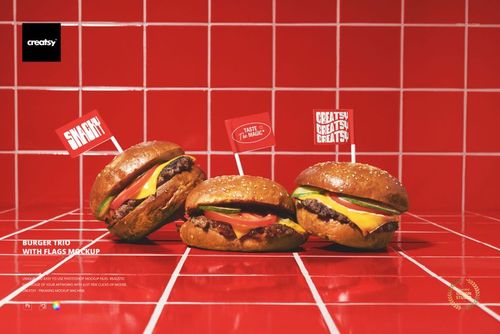Three burgers with cheese, tomato, and lettuce are displayed on a red tiled surface, each topped with a flag in a PSD mockup.