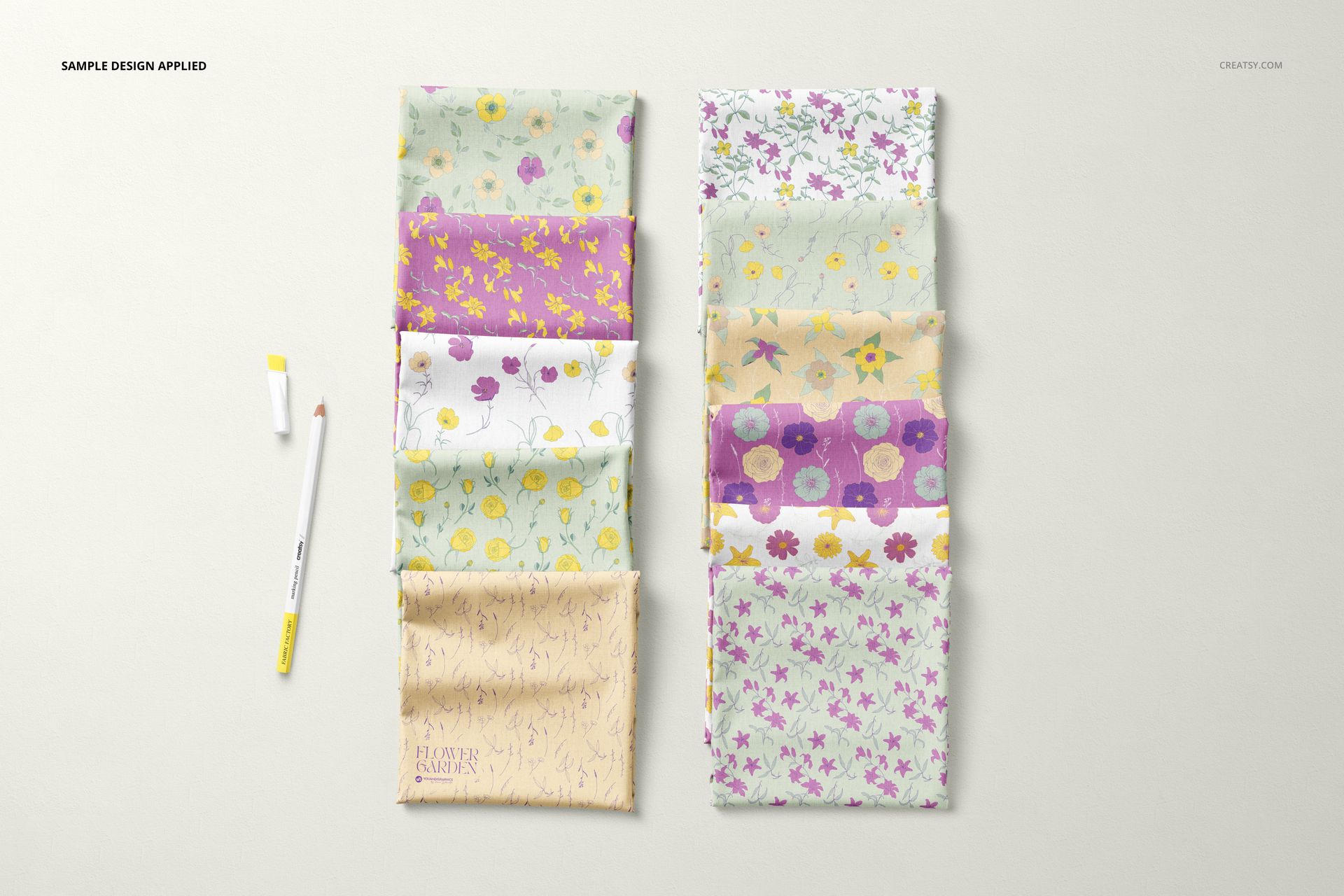 PSD mockup displaying multiple folded fabric samples with soft flower designs, placed side by side on a neutral background.