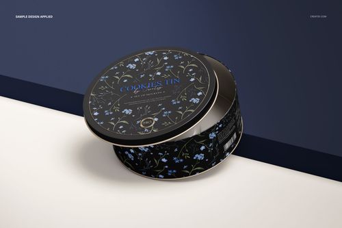 PSD mockup of a round cookie tin featuring a black background with blue flowers, displayed in a realistic setting.