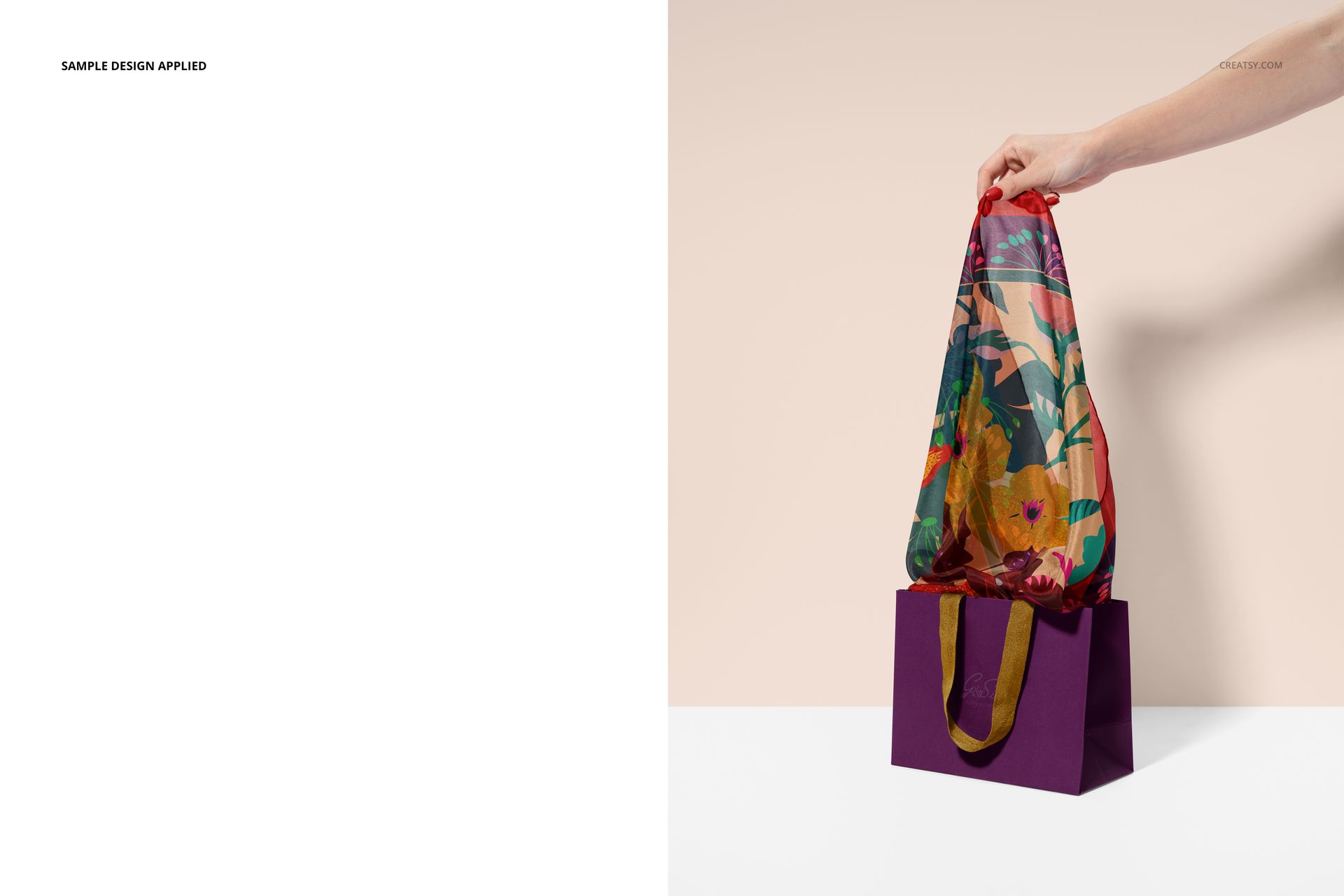 PSD mockup showing a patterned habotai silk scarf partially out of a purple paper bag, hand and beige backdrop included.