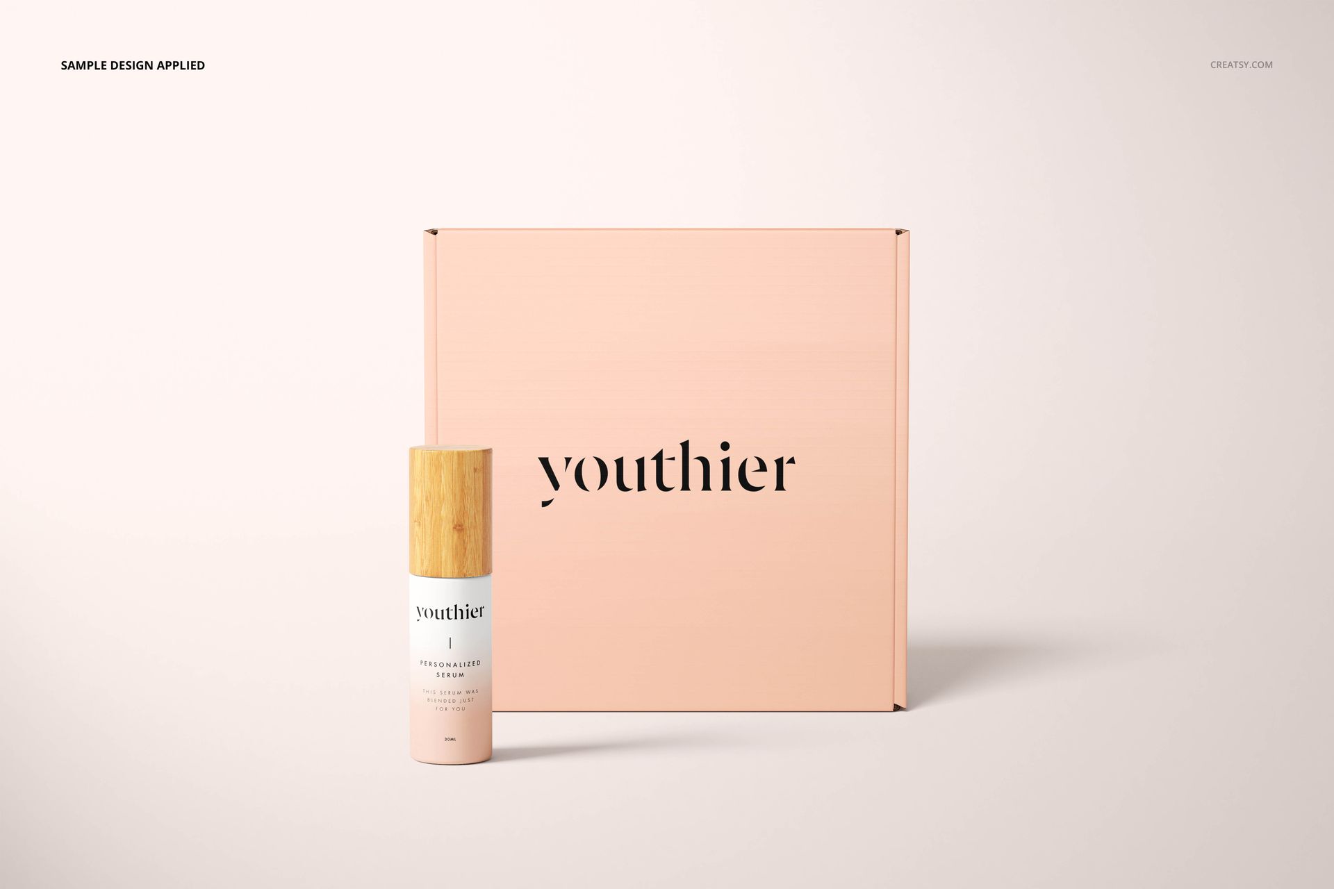 Cosmetic mailing box mockup in soft pink with simple black lettering, shown with a bottle featuring a wooden cap.