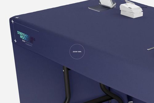 Rectangular table covered with a solid navy blue tablecloth, viewed from an angled side perspective in a mockup scene.