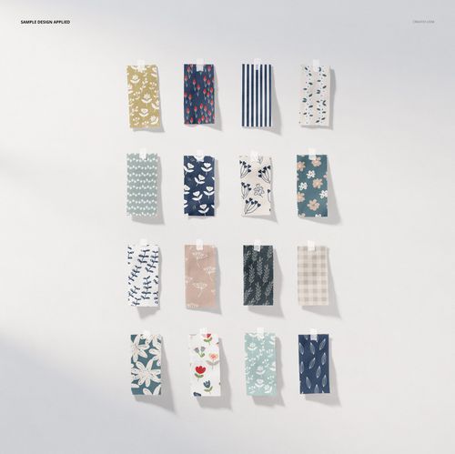 Fabric pieces mockup set showing sixteen rectangular fabric swatches with various patterns and colors, top view.