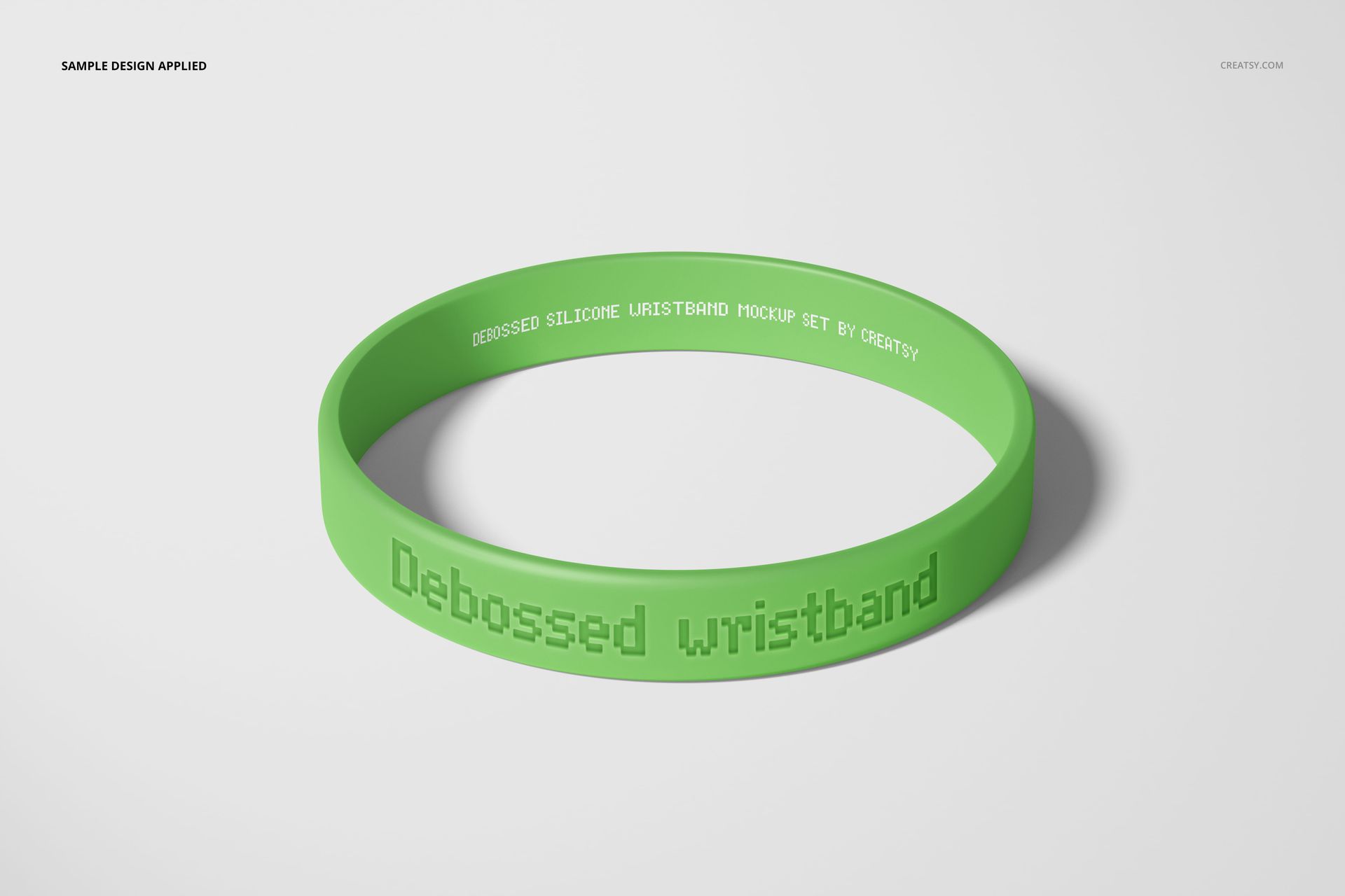 Single green debossed silicone wristband mockup with visible text, placed on a plain white surface.