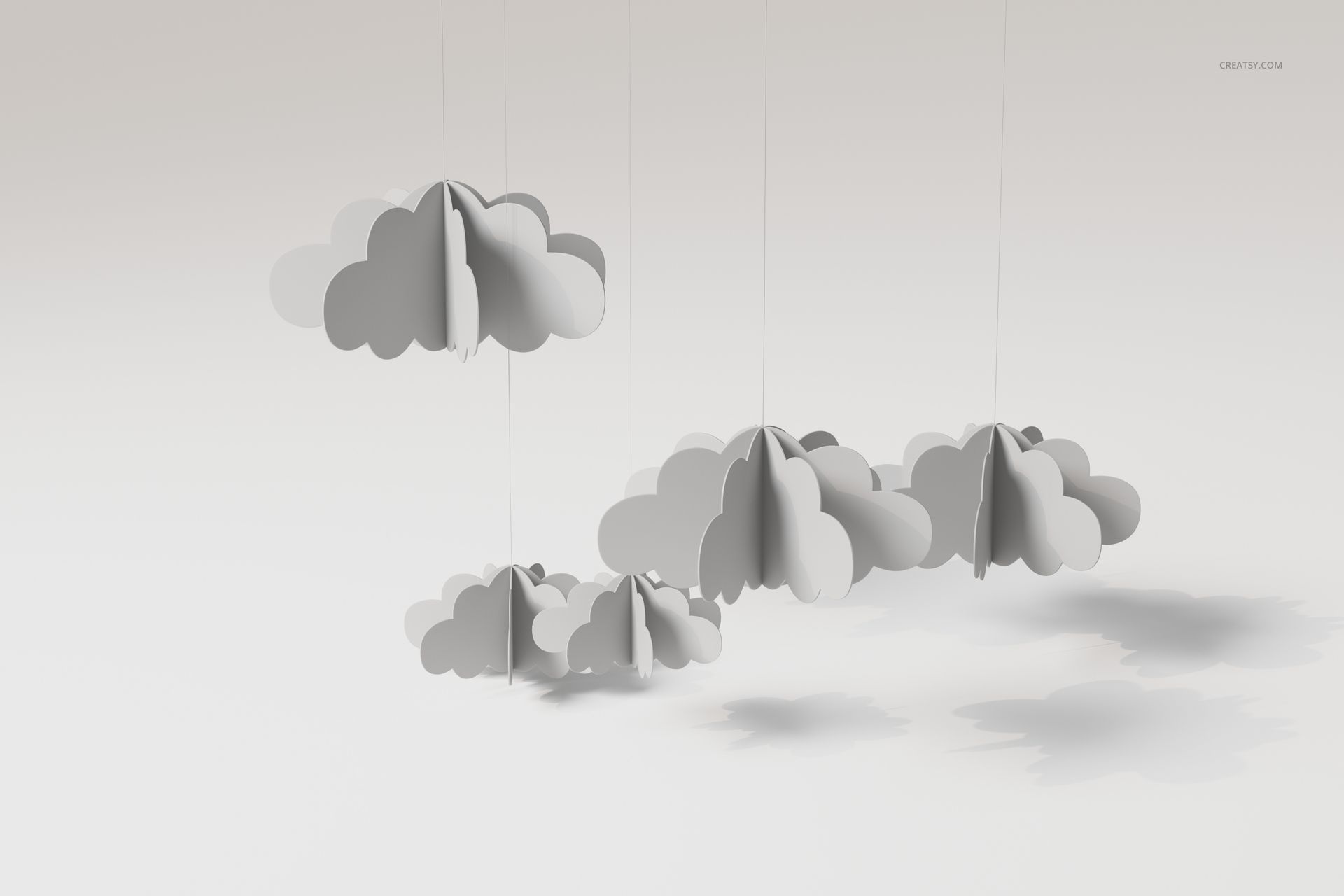 Front view of a baby mobile featuring multiple 3D cloud shapes in white and gray, suspended by thin strings.