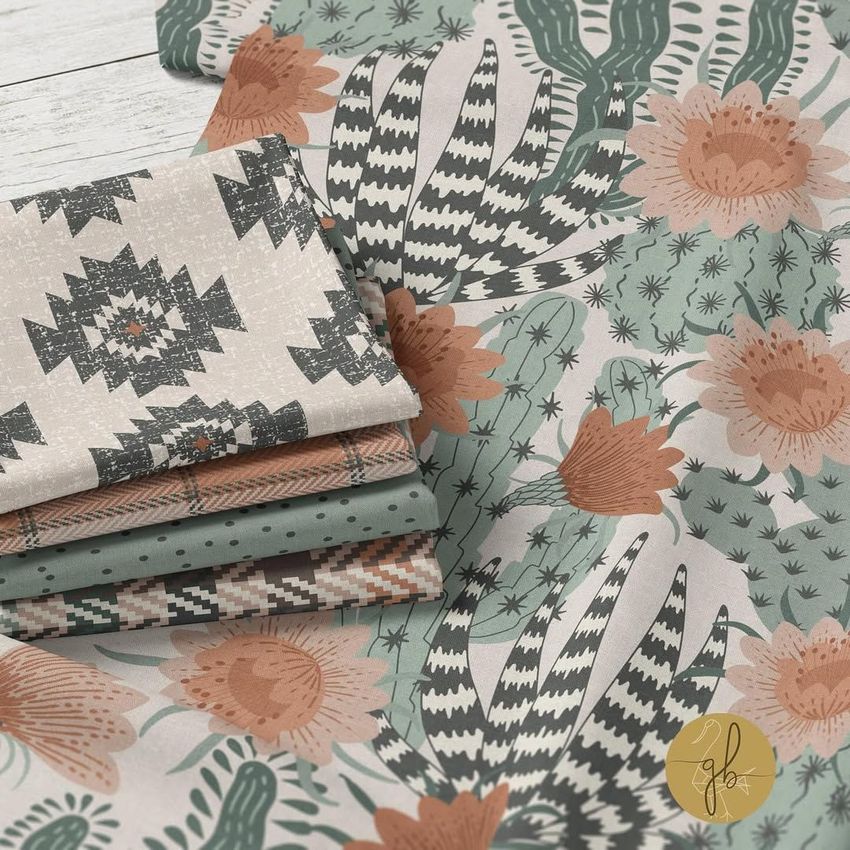 Folded fabric mockup featuring stacked textiles with southwestern patterns in earthy tones, displayed on a white wooden surface.