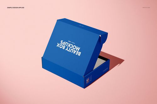Open blue mailing box mockup displayed on a light pink surface, showing the interior and lid from a side angle.