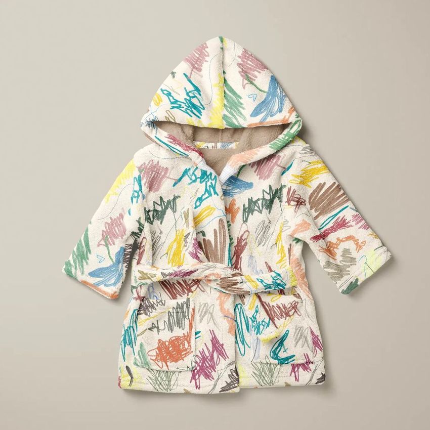 Baby bath dressing gown mockup featuring a hooded robe with colorful crayon scribble patterns on a neutral background.