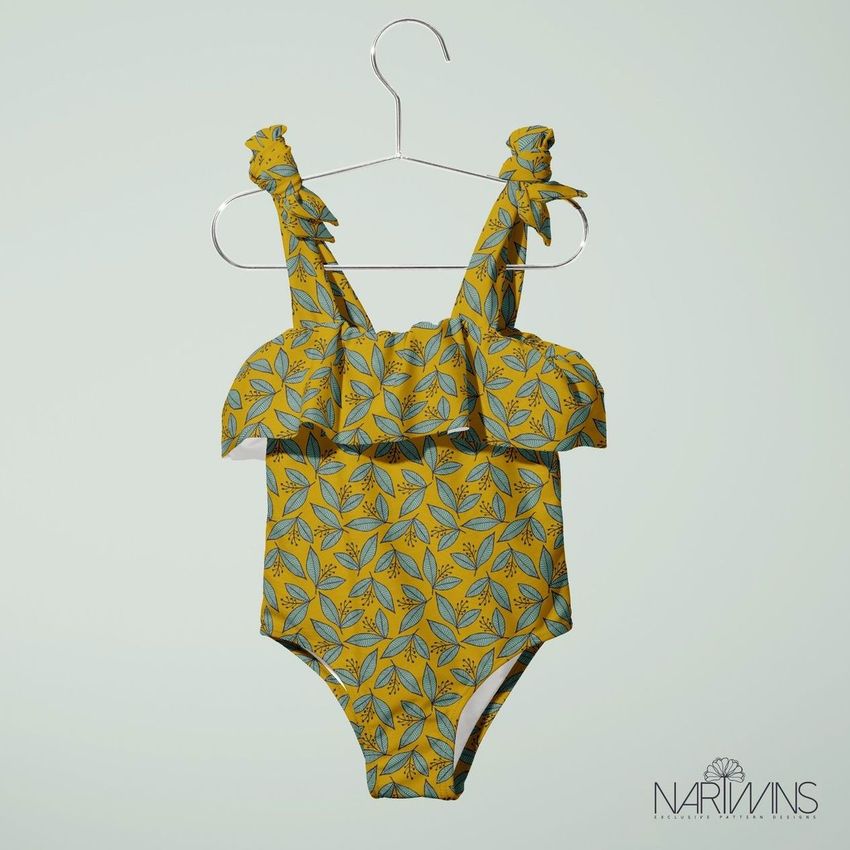 Baby swimsuit mockup featuring a yellow one-piece with a blue and green floral pattern, displayed on a hanger against a light background.