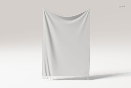 Front view of a plain white fringed tapestry blanket hanging against a neutral background with soft lighting.