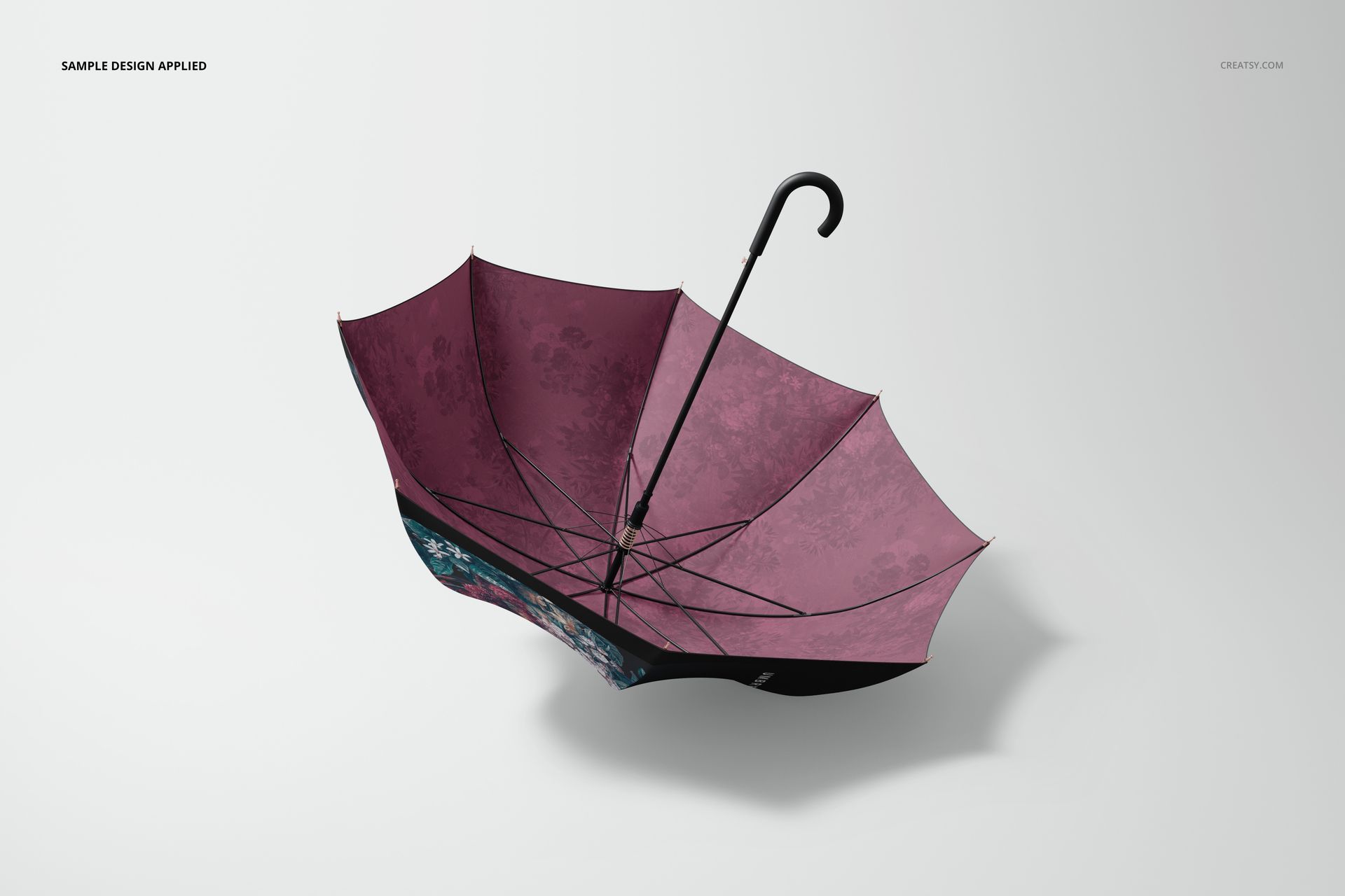 Open umbrella mockup with a maroon canopy featuring subtle floral patterns, viewed from a top angle on a light background.