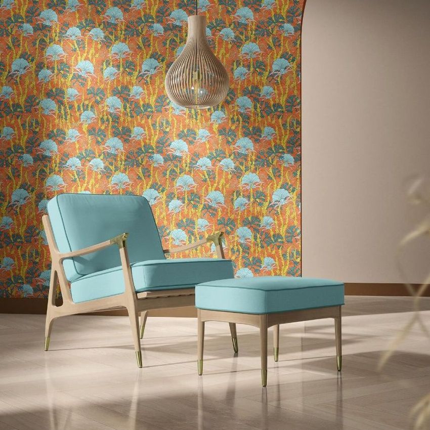 Lounge chair and ottoman mockup set in a modern room with light wood flooring and a vibrant coral and blue patterned wallpaper.