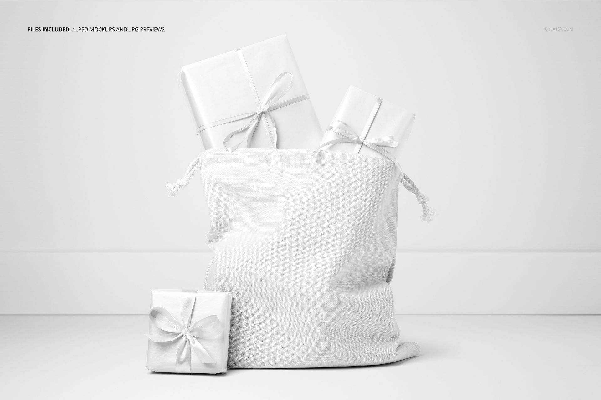 Christmas-themed PSD mockup showing a white fabric Santa bag and ribboned presents on a simple white surface.