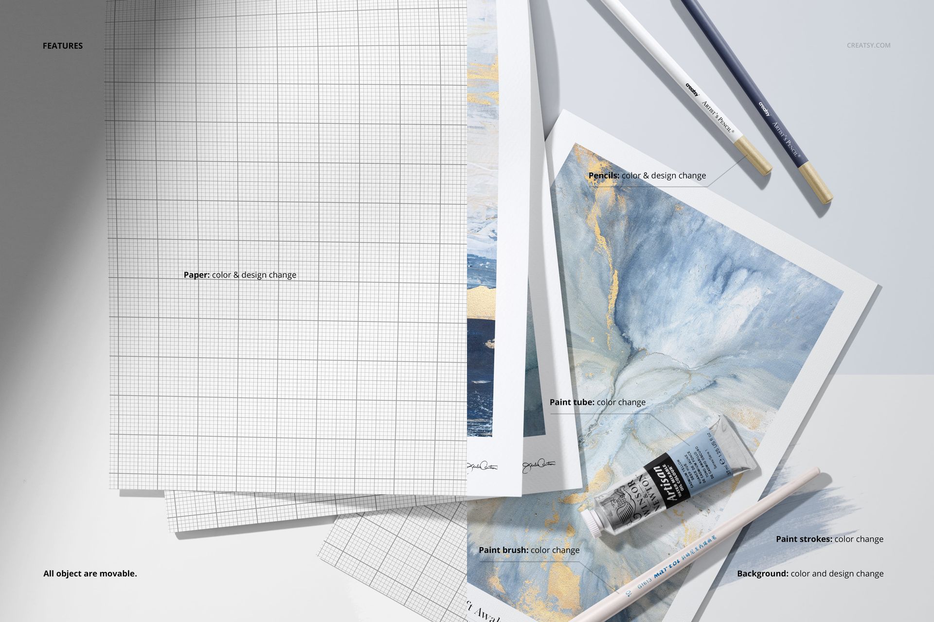 Top view of a paper pad mockup with grid sheets, paintbrushes, paint tube, and abstract painted paper on a white surface.