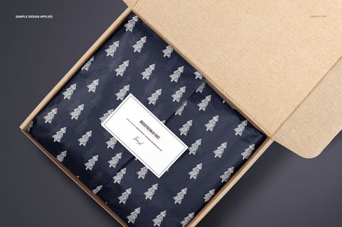 PSD mockup of a cardboard mailer box with patterned tissue paper and a rectangular label, shown from a top view.