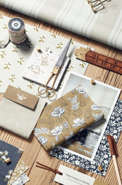 Top view of a rustic moodboard mockup featuring various patterned fabric samples, scissors, and decorative items.