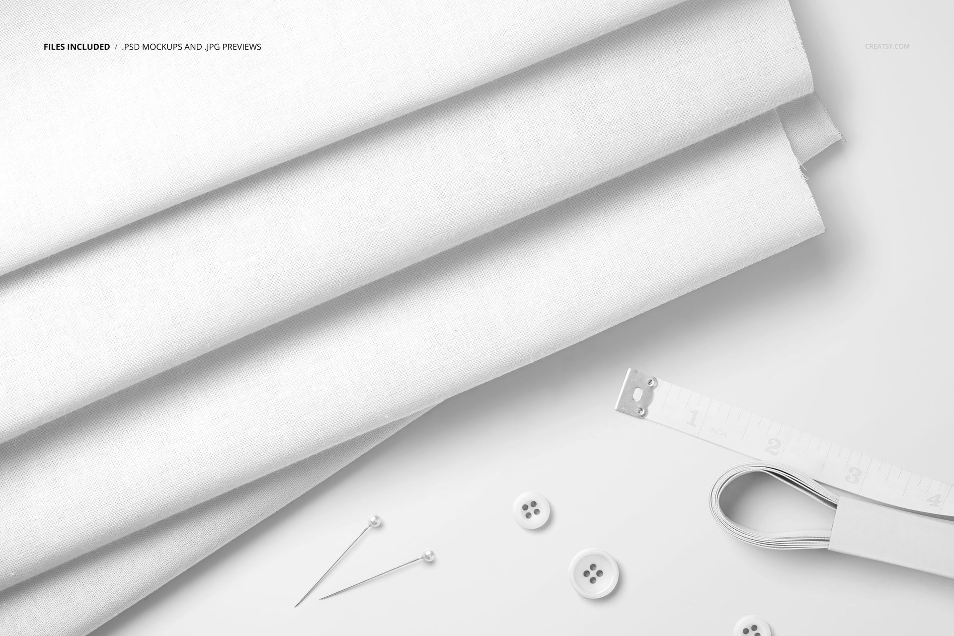 Top view of plain cotton fabric mockup with a measuring tape, white buttons, and sewing pins arranged on the surface.