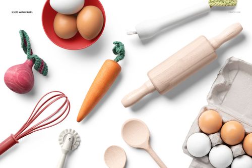 Kids apron mockup scene featuring eggs, wooden utensils, rolling pin, whisk, and playful carrot prop on white background.