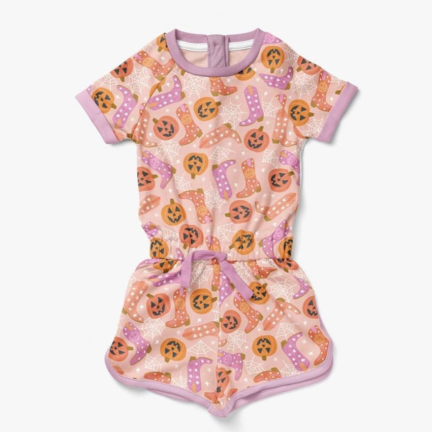 Girls cotton playsuit mockup featuring a short-sleeve romper with a Halloween-themed pattern of pumpkins and cowboy boots.