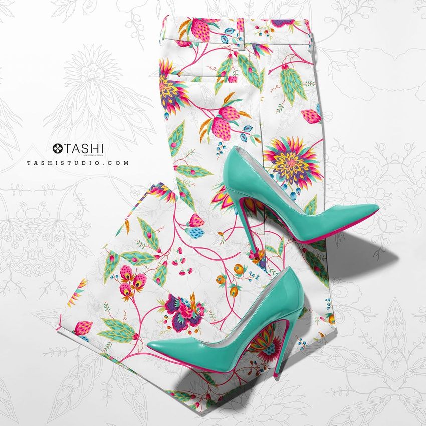Blazer trousers mockup featuring a vibrant floral print in pink, green, and yellow, paired with teal high-heeled shoes on a white background.