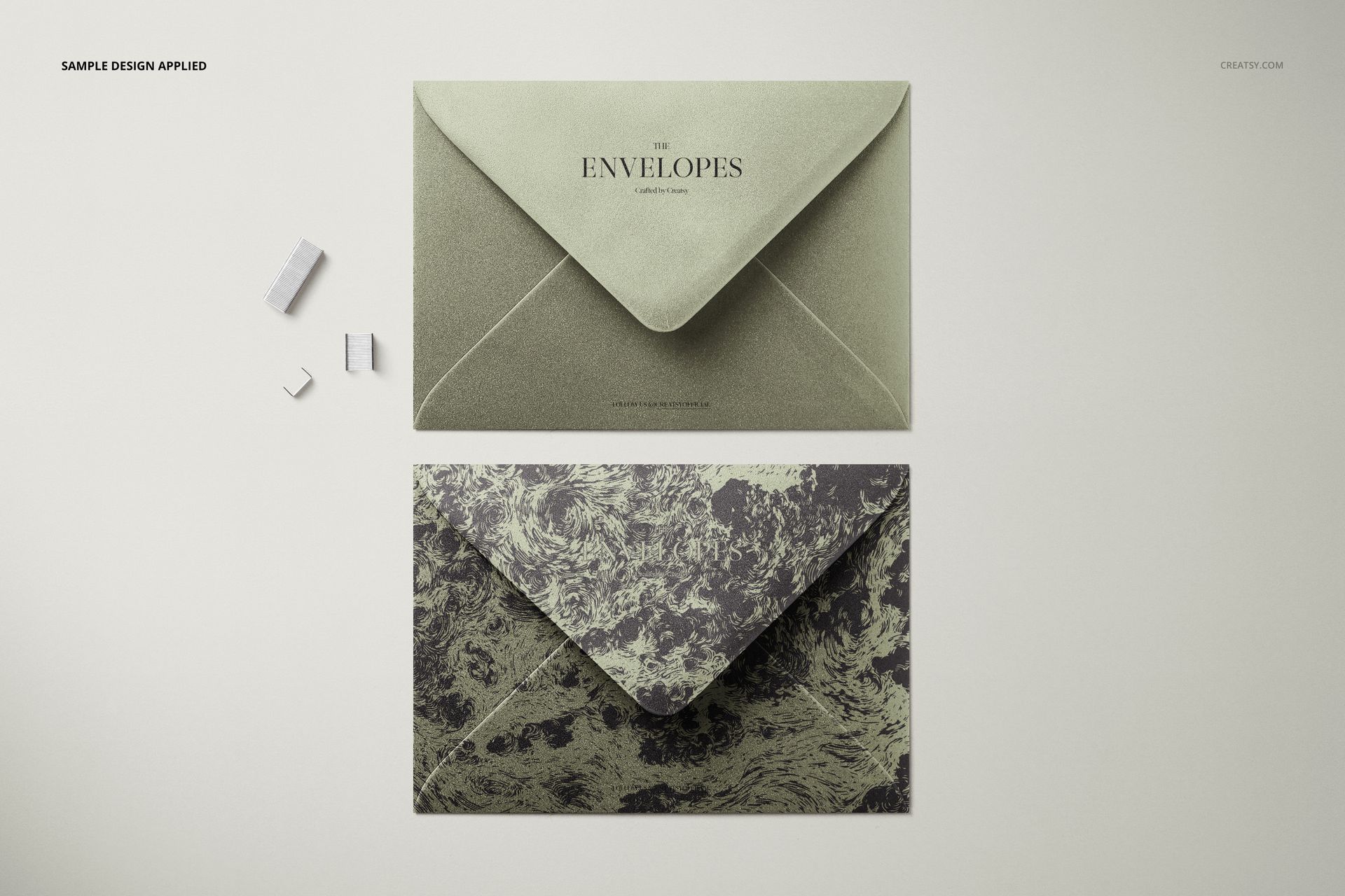 C6 envelope PSD mockup featuring a solid green envelope and a marbled envelope, photographed from a bird’s-eye perspective.