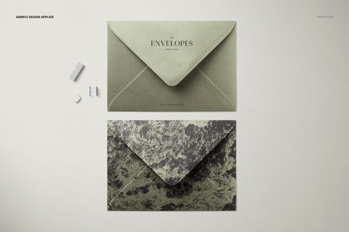 C6 envelope PSD mockup featuring a solid green envelope and a marbled envelope, photographed from a bird’s-eye perspective.