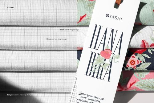 PSD mockup showing a neat pile of patterned jersey fabric with a detailed close-up of a label tag in the foreground.