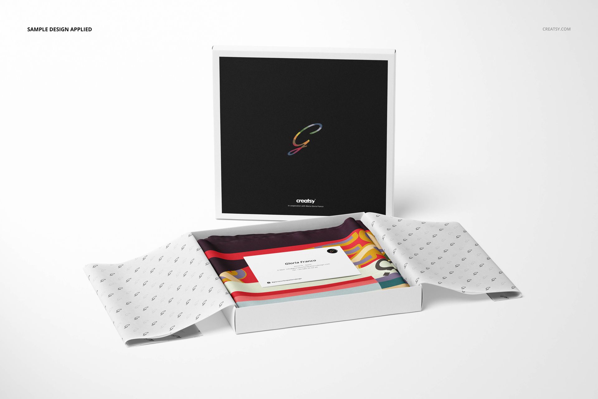 Front view of a fashion accessory mockup set featuring a silk scarf in a box, patterned tissue, and a printed card.