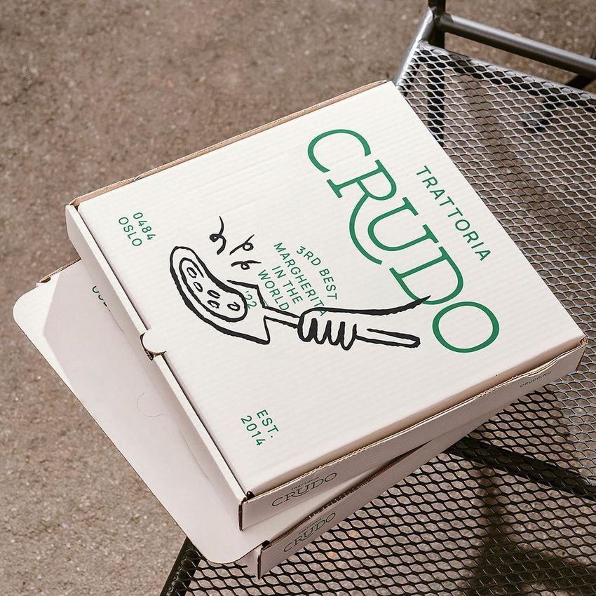 Pizza box mockup placed on a metal outdoor table, featuring a white box with green text and a simple pizza illustration.