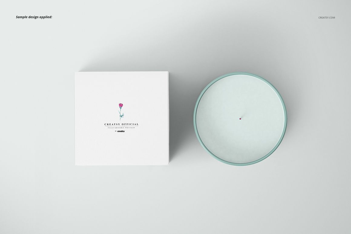 Candle mockup set showing a round candle with white wax and a matching box, both displayed from above on a pale surface.