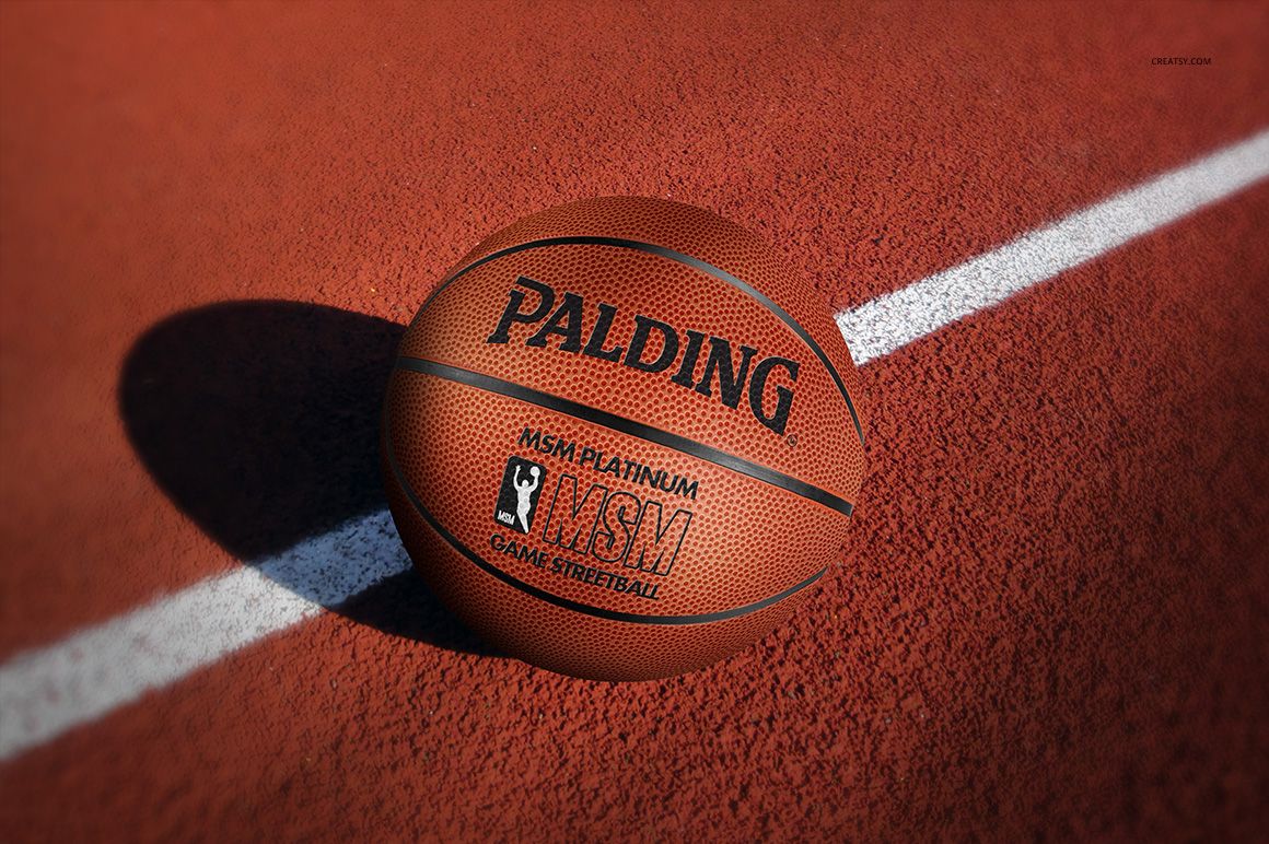 Close-up view of a basketball mockup featuring pebbled texture and black lettering on a red court background.