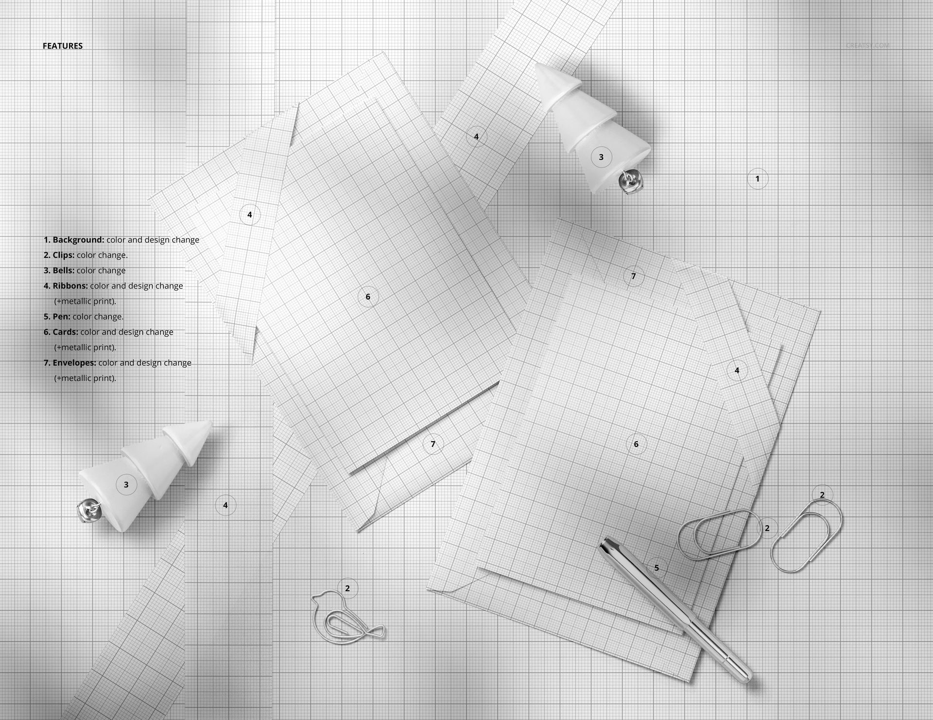 Top view of two Christmas card mockups with matching envelopes on a grid background, surrounded by props like a pen and ribbon.
