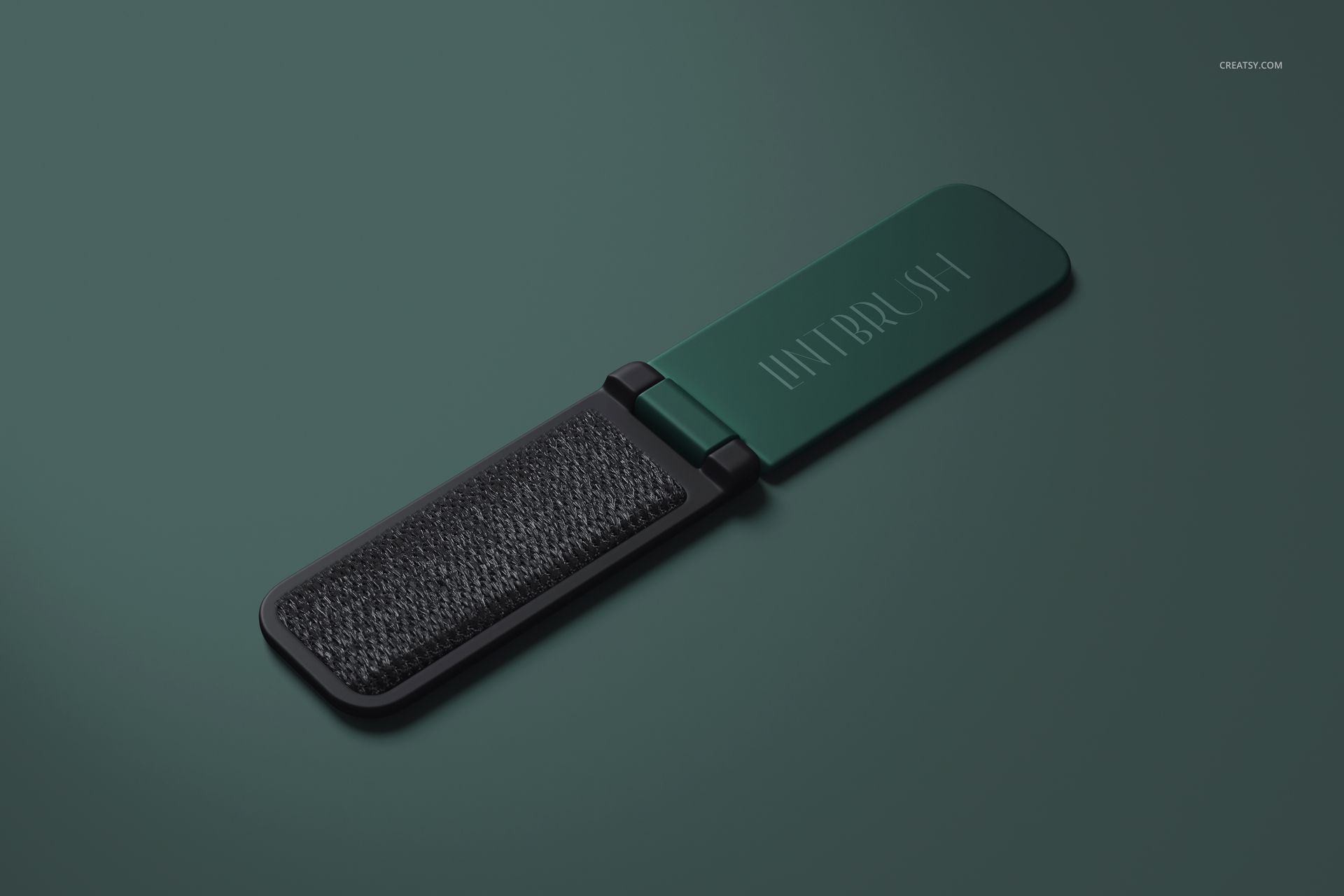 Open folding lint brush and shoe horn mockup in green and black, shown from above on a minimalist green surface.