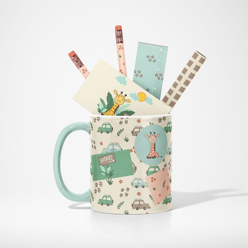Mug mockup with safari-themed illustrations holding pencils, a ruler, and patterned cards, set against a plain white background.