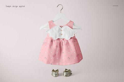 Pink baby dress mockup with white collar and decorative buttons, shown on a hanger with metallic baby shoes below.