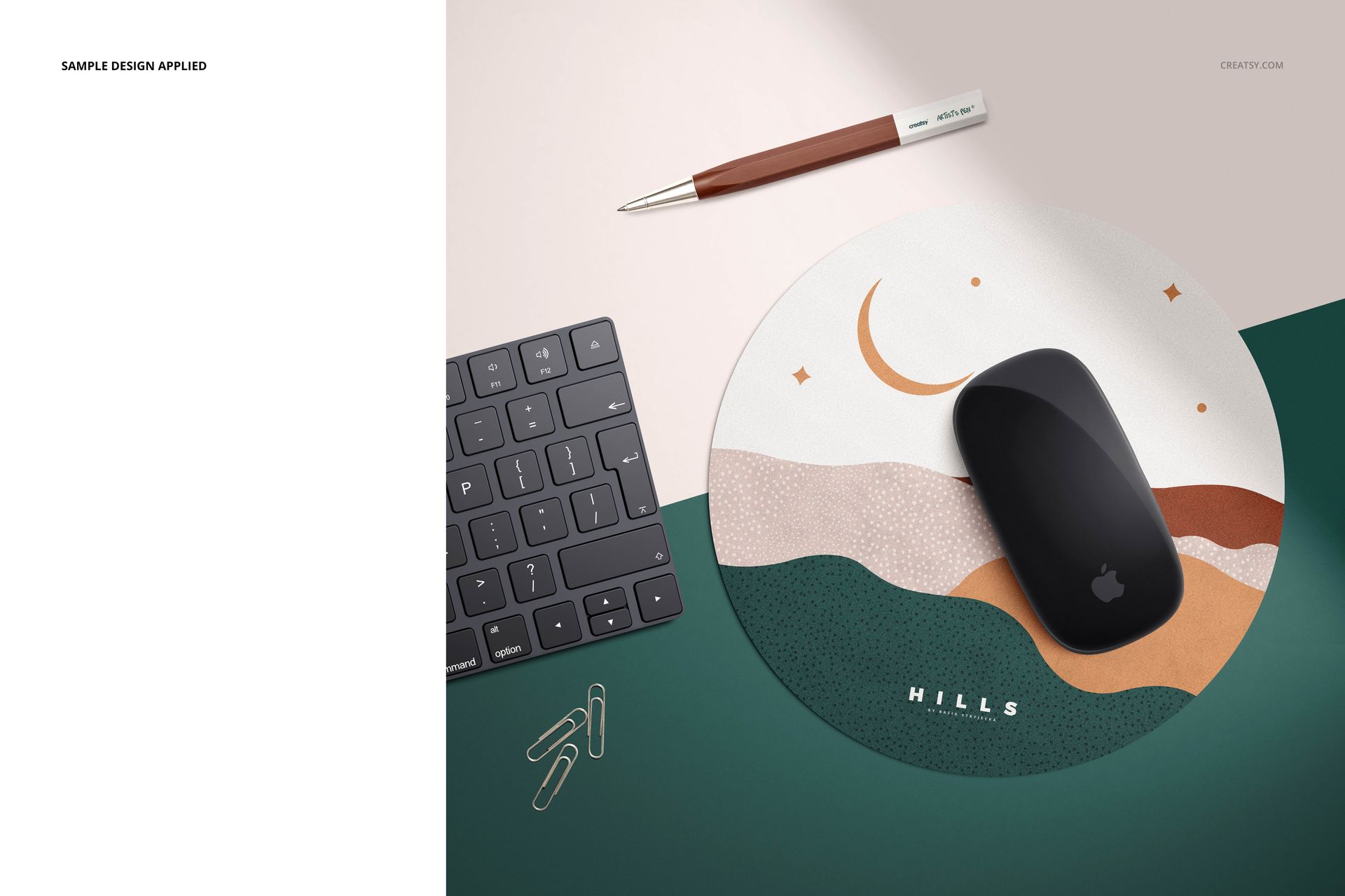 Top view of a round mouse pad mockup featuring geometric shapes, placed beside a keyboard, pen, and paper clips.