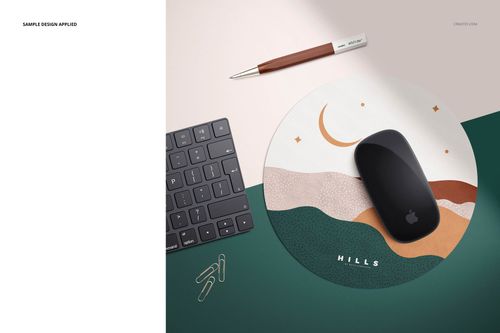 Top view of a round mouse pad mockup featuring geometric shapes, placed beside a keyboard, pen, and paper clips.