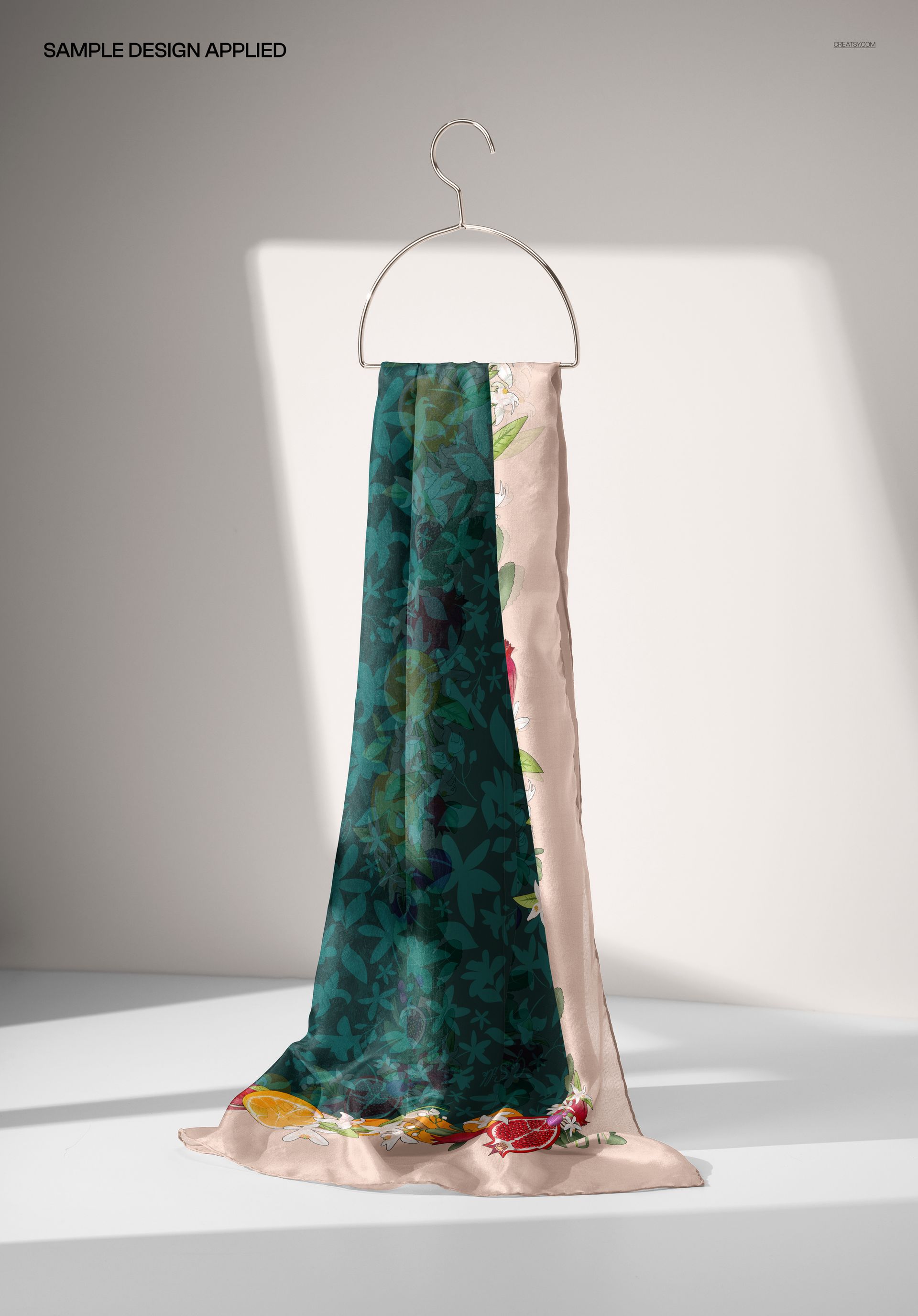 PSD mockup of a hand-rolled silk scarf featuring botanical designs, draped on a hanger with shadowed background.