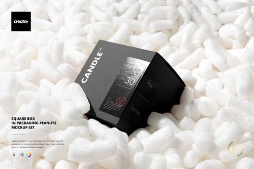 Square box with dark design placed among white packaging peanuts, shown in a front angled view for a packaging mockup.