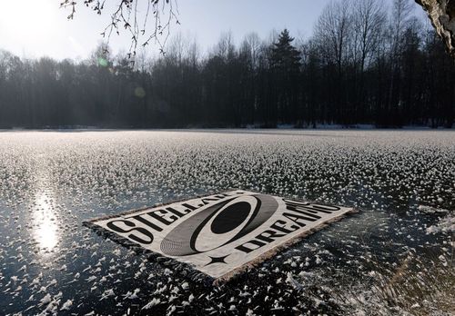 Winter-themed jacquard blanket mockup featuring geometric design, laid flat on icy lake with trees in background.