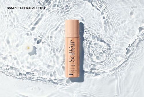 Serum pump bottle with beige label lying on rippled water surface, viewed from above in a cosmetics mockup scene.
